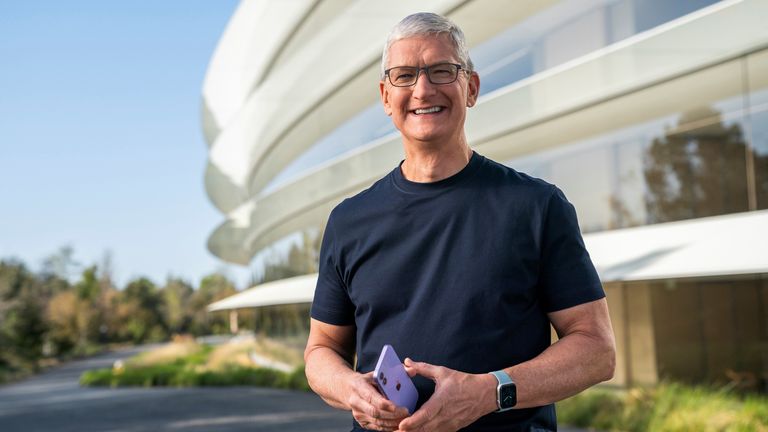 Apple CEO Tim Cook holds an iPhone 12 in a new purple finish
