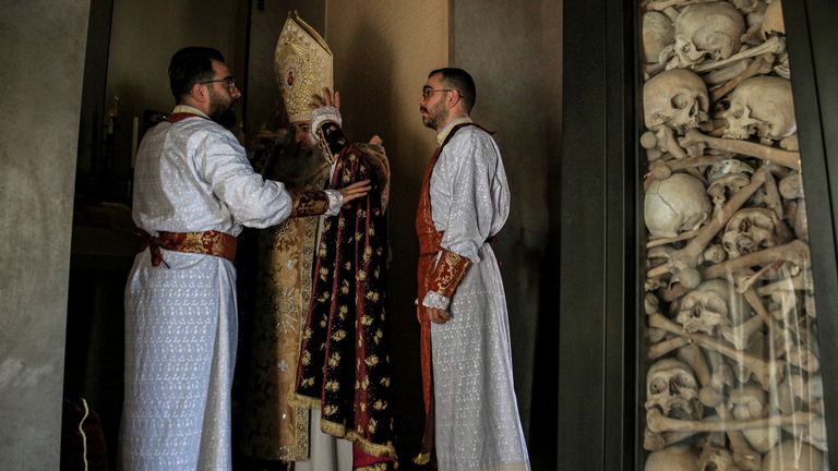 A Lebanese-Armenian bishop adjusts his garment inside the cemetery of Armenians. Pic: Associated Press