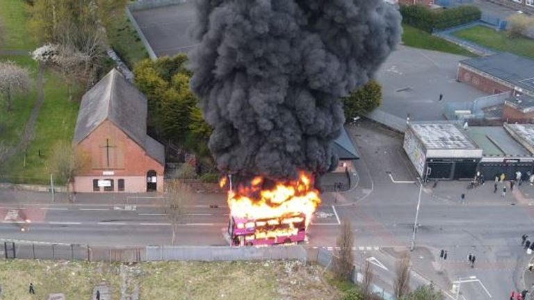 Smoke billows over a neighbourhood in Belfast after a bus was set on fire on another evening of violence.