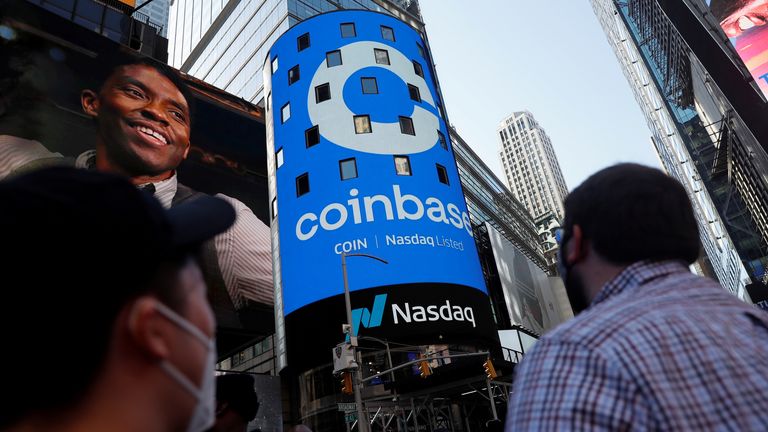 People watch the logo of Coinbase Global Inc, the largest US cryptocurrency exchange, display on the jumbotron Nasdaq MarketSite in Times Square in New York