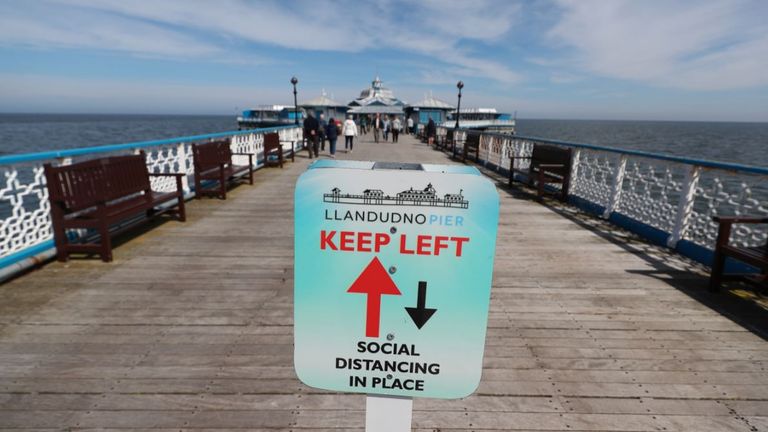 A social distancing sign on the pier in Llandudno, Wales