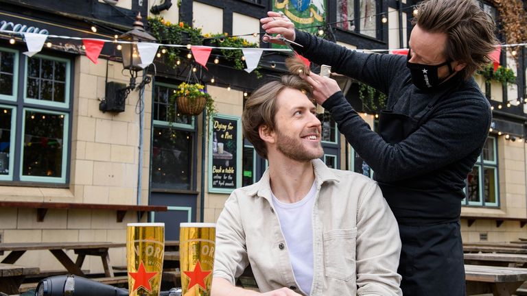 Joe Foyster managed to combine two of things people have been missing at a pop-up hairdressing station at The Gregorian pub in Bermondsey, London. Barber Michael Douglas makes sure there's a good head on it