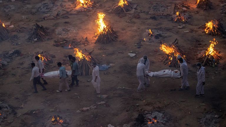 The bodies of COVID-19 victims are carried into a crematorium in Delhi