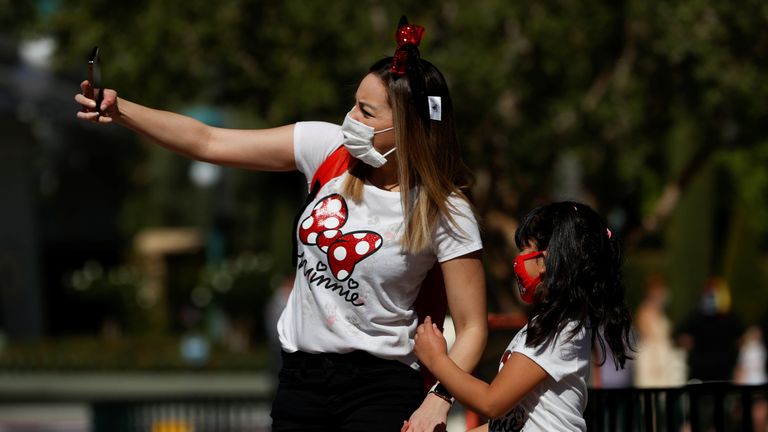 People take a selfie outside Disneyland Park on its reopening day amidst the coronavirus disease (COVID-19) outbreak, in Anaheim, California, U.S., April 30, 2021. REUTERS/Mario Anzuoni