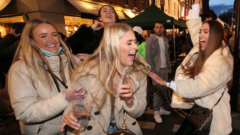People celebrate being out for the evening in Old Compton Street, Soho, central London, where streets have been closed to traffic to create outdoor seating areas for the reopening bars and restaurants 12/4/2021