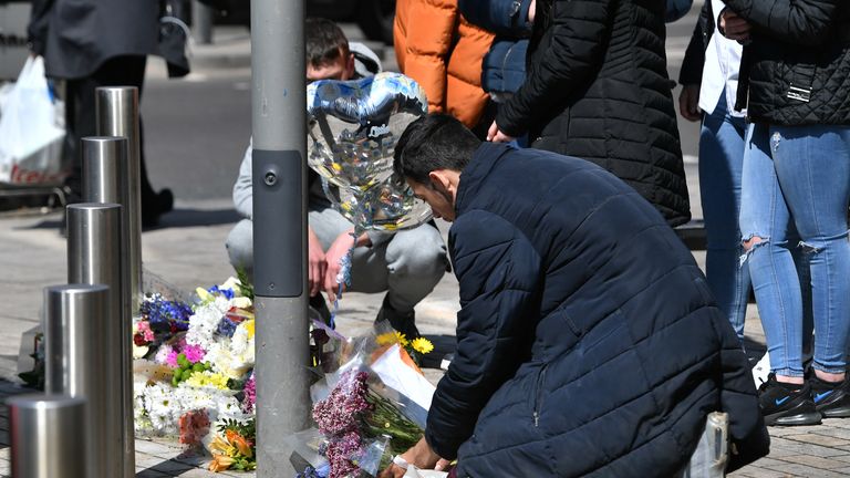 People place flowers at the scene of the murder of 14-year-old Fares Maatou  in Barking Road, East Ham