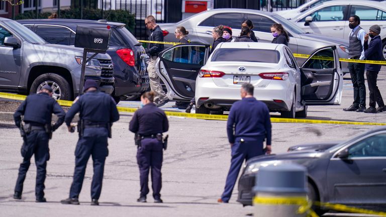 Authorities confer at the scene where multiple people were shot. Pic: AP