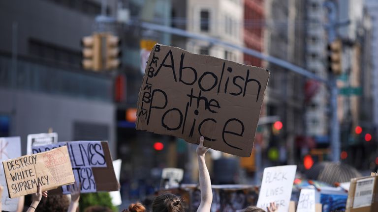 Demonstrators hold signs during a protest against police brutality in the aftermath of the death of George Floyd in Manhattan, New York