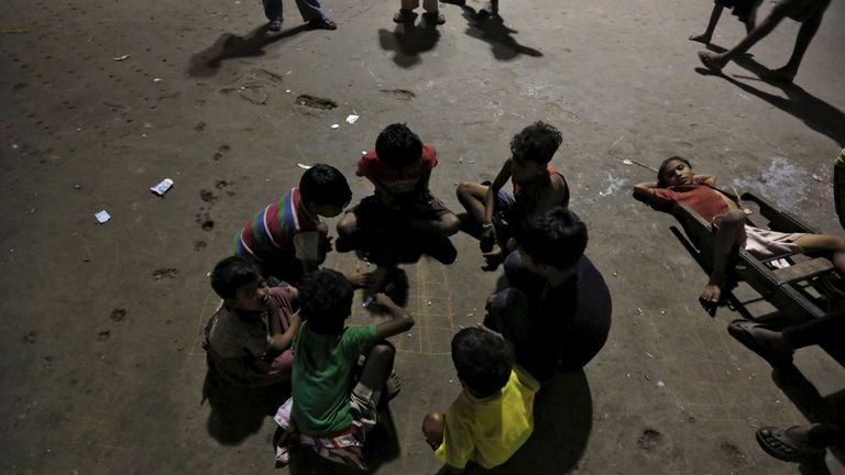 Les enfants sans-abri jouent dans un parking d'une gare de Kolkata, Inde, le 14 mars 2016