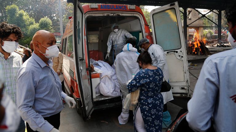 Health workers prepare to take out from an ambulance bodies of six people who died of COVID-19 . Pic: AP