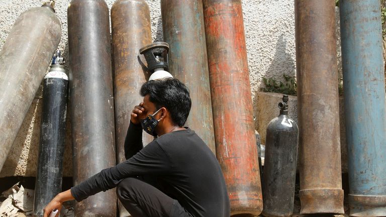 A man waits outside a factory to get his oxygen cylinder refilled amid the continuing surge in coronavirus infections in India