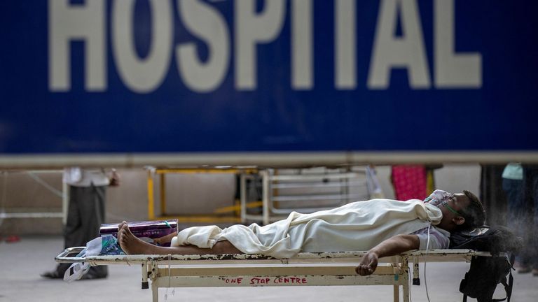 A patient suffering from coronavirus waits to be admitted to hospital in Delhi