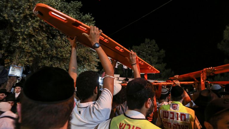Rescue workers carry stretchers as they try to reach survivors