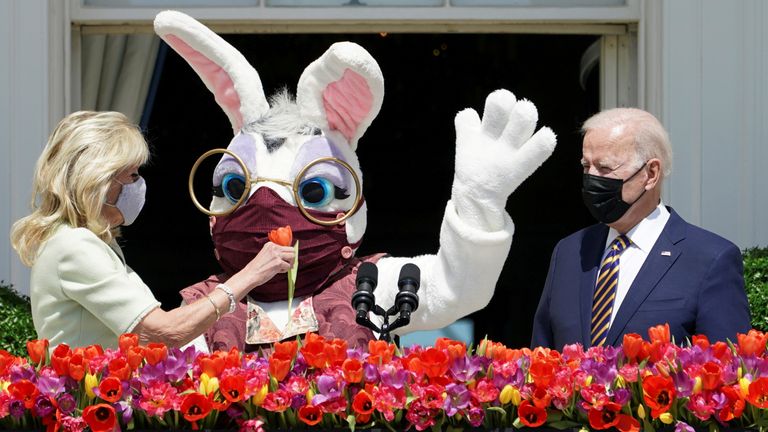 U.S. President Joe Biden stands to deliver his remarks on the tradition of Easter, next to first lady Jill Biden holding a flower and a person wearing an Easter Bunny costume at the Blue Room Balcony of the White House in Washington, U.S. April 5, 2021