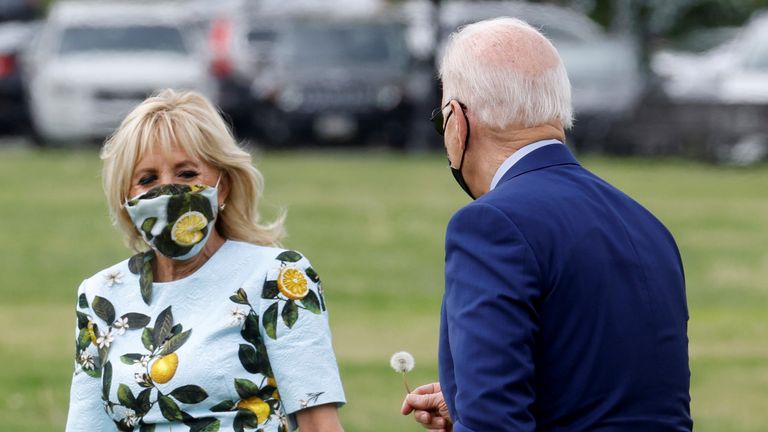 U.S. President Joe Biden stops to pick a dandelion for first lady Jill Biden as they walk to board the Marine One helicopter on the Ellipse near the White House in Washington, U.S., April 29, 2021. REUTERS/Jonathan Ernst TPX IMAGES OF THE DA