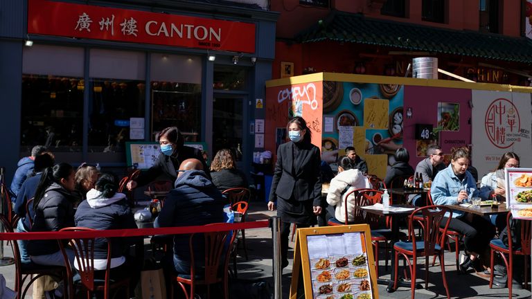 People sit at setup tables outside a restaurant in Chinatown, in London, on Saturday. Pic: AP