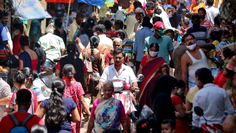 People are seen at a crowded marketplace in a slum area of Mumbai