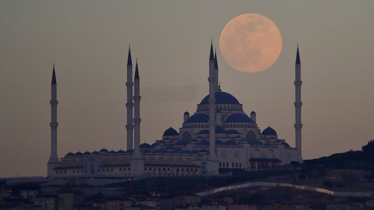 The full moon, also known as the Supermoon, rises above the Camlica Mosque in Istanbul, Turkey, April 26, 2021. REUTERS/Murad Sezer