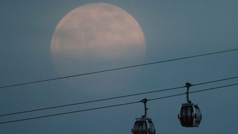 القمر المكتمل ، المعروف أيضًا باسم Supermoon ، يرتفع فوق تلفريك خط طيران الإمارات في لندن ، بريطانيا ، 26 أبريل 2021. REUTERS / Hannah McKay TPX IMAGES OF THE DAY