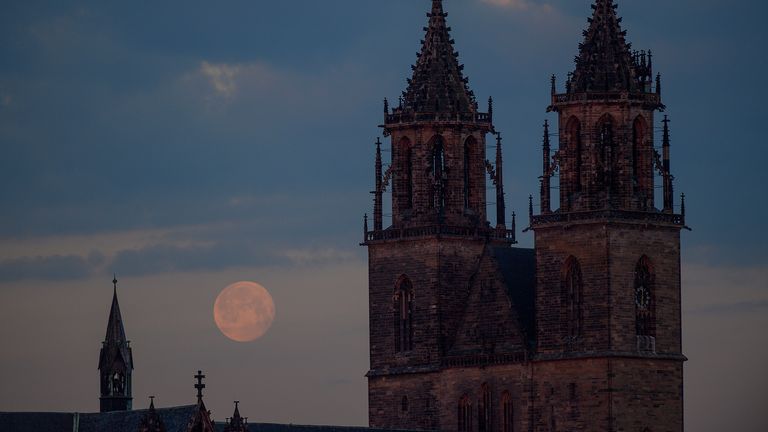 La lune se couche derrière la cathédrale de la capitale de l'état de Saxe-Anhalt, Magdebourg.  Pic: AP