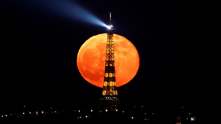 La pleine lune, connue sous le nom de "Super lune rose" se dresse derrière la Tour Eiffel pendant un couvre-feu national en raison de mesures plus strictes contre la propagation de la maladie à coronavirus (COVID-19) à Paris, France, le 27 avril 2021. REUTERS / Christian Hartmann TPX IMAGES DU JOUR