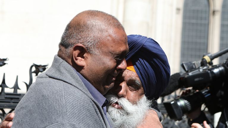 L'ancien employé du bureau de poste Harjinder Butoy (à gauche) embrasse son père devant la Royal Courts of Justice