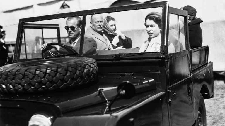Queen Elizabeth II sits in the front seat of a Land-Rover vehicle as her husband, the Duke of Edinburgh, drives on the grounds of Windsor Great Park in London, England, May 19, 1955