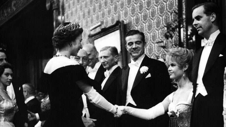 The Queen and Princes Margaret attended the annual Royal Commander film screening at the Empire Theatre, Leicester Square in London on the evening of 29 October 1956. The film chosen as the representative production this year was 'The Battle of the River Plate'.  The photo shows Princess Margaret looking to the left as French actress Brigitte Bardot greets the Queen in the theater foyer before the show's centerpiece is Dana Andrews.  (AP photo).  Photo: AP