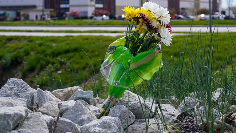 A single bouquet of flower sits in the rocks across the street from the FedEx facility in Indianapolis. Pic: AP