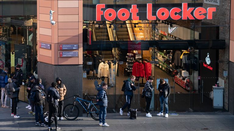 مردم دوشنبه ، 12 آوریل 2021 ، قبل از بازگشایی آن ، در خارج از یک مغازه در لیورپول ، انگلیس صف می کشند.  عکس: AP