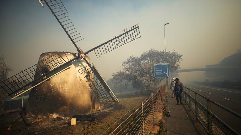 The historic Mostert&#39;s Mill smoulders as firefighters battle to contain a fire that broke out on the slopes of Table Mountain in Cape Town