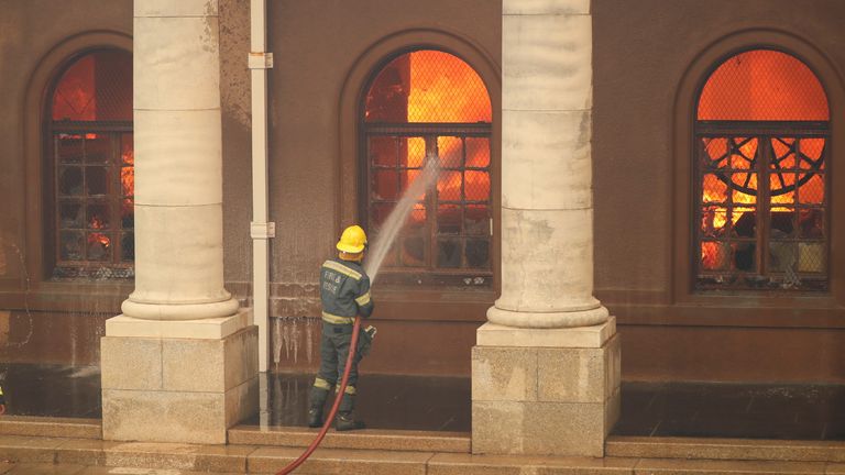 Firefighters battle flames as the library at the University of Cape Town burns after fire broke out on the slopes of Table Mountain in Cape Town