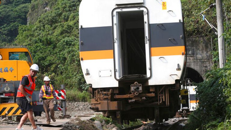 Rescue workers remove a part of the derailed train near Taroko Gorge in Hualien, Taiwan 
