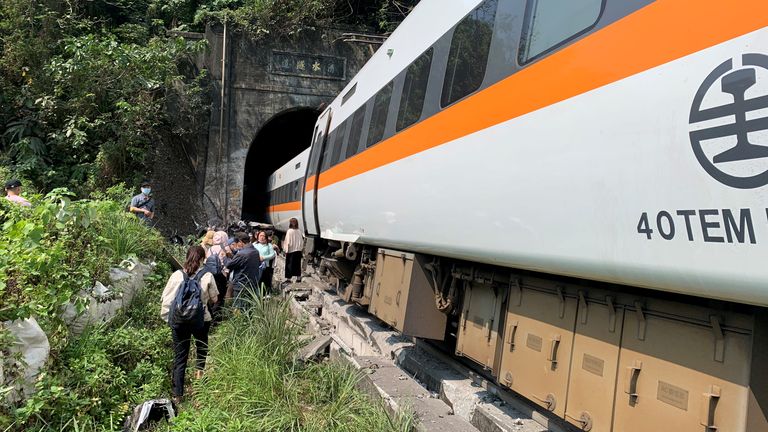 Des gens marchent à côté d'un train qui a déraillé dans un tunnel au nord de Hualien, Taiwan, le 2 avril 2021, sur cette image fournie par l'Agence nationale des incendies de Taiwan.  Agence nationale des incendies de Taiwan / Document via REUTERS ATTENTION AUX RÉDACTEURS - CETTE IMAGE A ÉTÉ FOURNIE PAR UN TIERS.  PAS DE REVENTE.  PAS D'ARCHIVES.