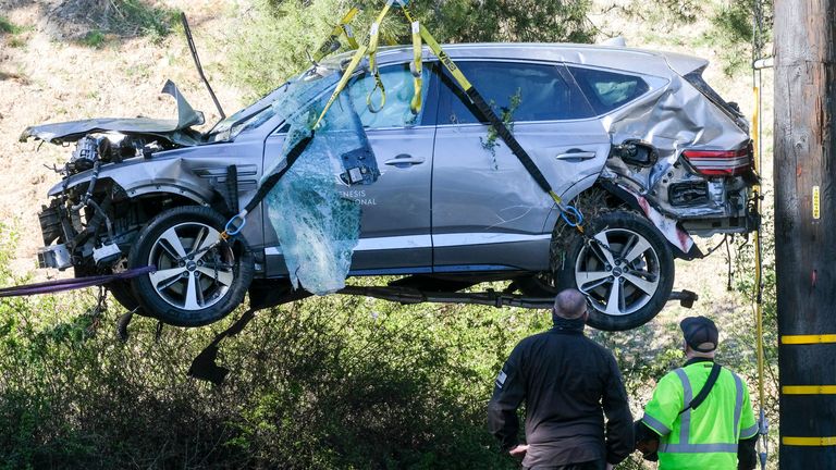 FILE - In this Feb. 23, 2021, file photo, a crane is used to lift a vehicle following a rollover accident involving golfer Tiger Woods, in the Rancho Palos Verdes suburb of Los Angeles. Authorities said Wednesday, April 7, Woods was speeding when he crashed leaving him seriously injured. (AP Photo/Ringo H.W. Chiu, File)