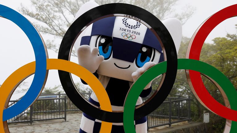 Tokyo Olympics mascot Miraitowa poses with the Games&#39;s rings after they are unveiled at a ceremony in Japan