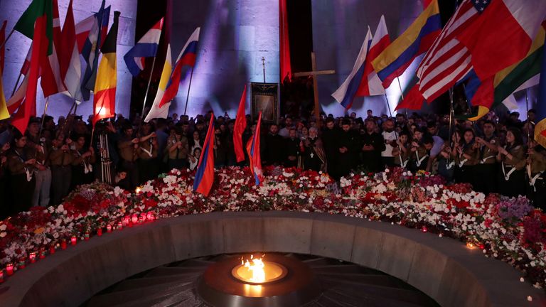 People lay flowers at the eternal fire of the Tsitsernakaberd memorial in Yerevan