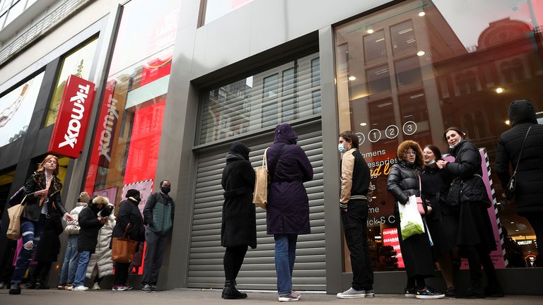 People stand outside a shop on Oxford street, as the coronavirus disease (COVID-19) restrictions ease, in London, Britain April 12, 2021. REUTERS/Henry Nicholls