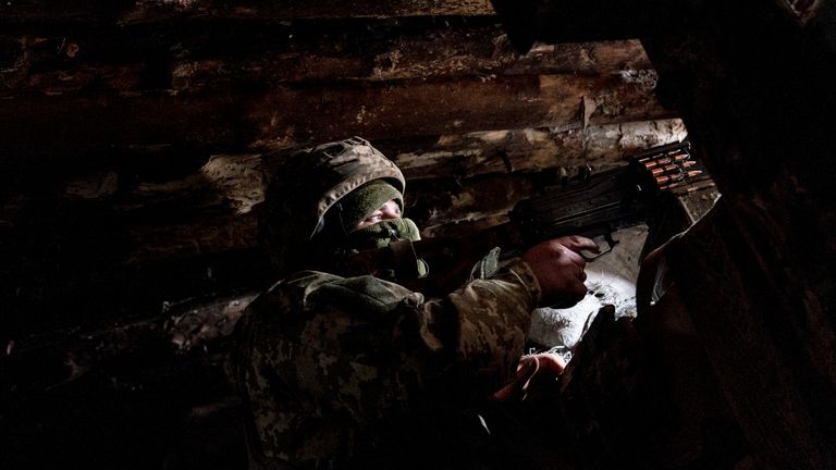 A Ukrainian serviceman keeps ready a machine gun in his shelter near the front-line town of Krasnohorivka, eastern Ukraine, Friday, March 5, 2021. The country designated 14,000 doses of its first vaccine shipment for the military, especially those fighting Russia-backed separatists in the east. But only 1,030 troops have been vaccinated thus far. In the front-line town of Krasnohorivka, soldiers widely refuse to vaccinate. (AP Photo/Evgeniy Maloletka)
