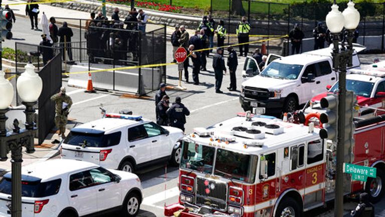 Police and fire officials stand near a car that crashed into a barrier on Capitol Hill. Pic: AP