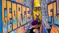 Damarra Atkins pays respect to George Floyd at a mural at George Floyd Square, Friday, April 23, 2021, in Minneapolis. (AP Photo/Julio Cortez)