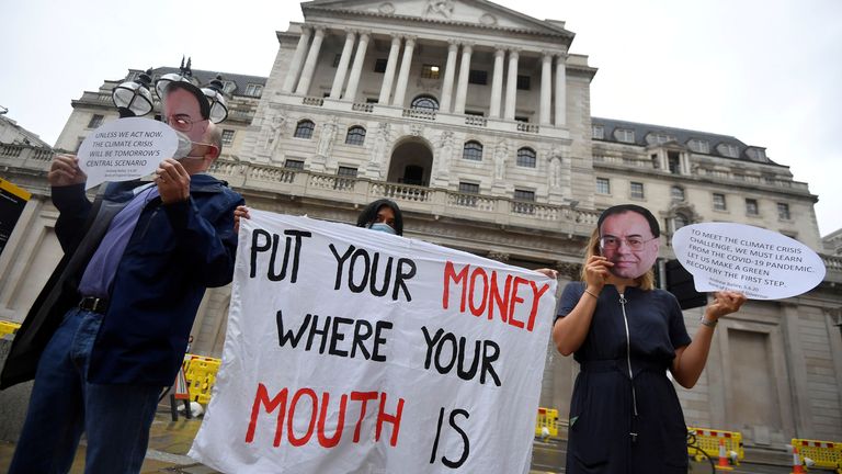 Environmental activists wear face masks depicting the governor of the Bank of England, Andrew Bailey, during a protest to encourage a green economy, outside of the Bank of England in the City of London, Britain, August 6, 2020