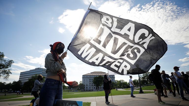 Cecilia Lopez, from Wisconsin, holds a Black Lives Matter flag 