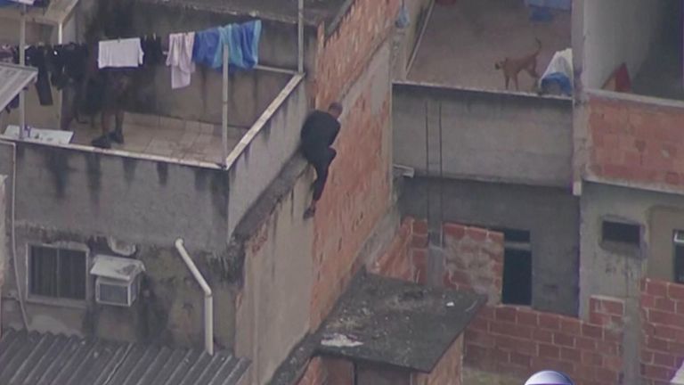 Suspects clamber over rooftops to evade police.
