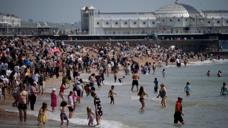 People venture into the sea as they enjoy themselves during a hot day on Brighton Beach, in Brighton, on England&#39;s south coast, Sunday, May 30, 2021. The bank holiday weekend and relaxation of England&#39;s coronavirus restrictions has enabled many people to visit beaches, as warm weather spreads across the UK after what has been a very rainy May. (AP Photo/Matt Dunham)