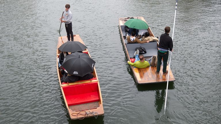 Les gens s'abritent sous des parapluies en barque le long de la rivière Cam à Cambridge alors que les conditions instables se déplacent à travers le pays