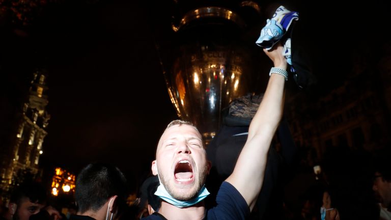 Fans celebrate in front of an inflatable trophy