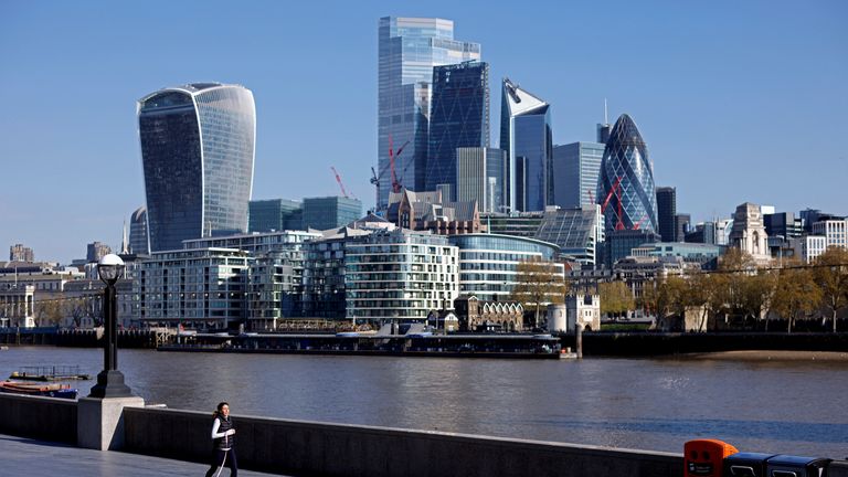 A woman exercises with a dog near the City of London financial district, in London, Britain, April 30, 2021