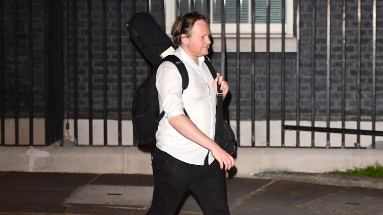 A man carrying a musical instrument leaves 10 Downing Street on Saturday