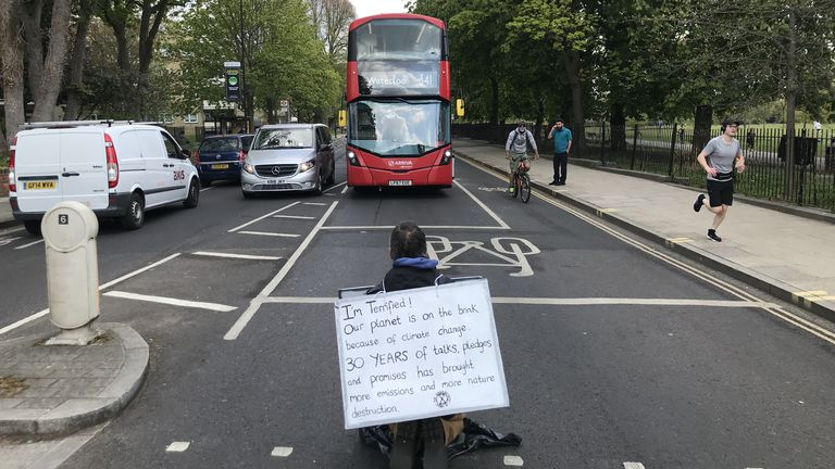 An Extinction Rebellion (XR) handout photo of a protester blocking traffic in Hackney, London
